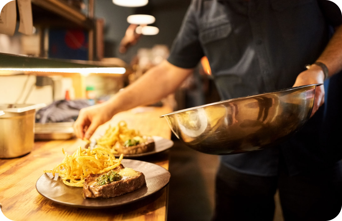 Chef preparing steak plates in kitchen
